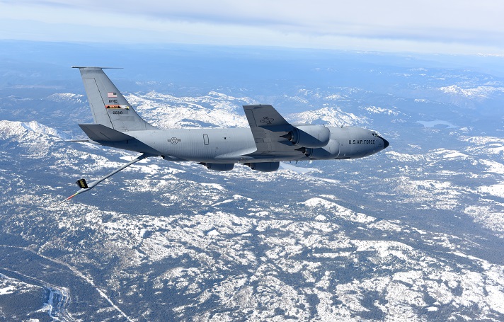 A KC-135 Stratotanker assigned to Beale Air Force Base flies over snowy mountains.